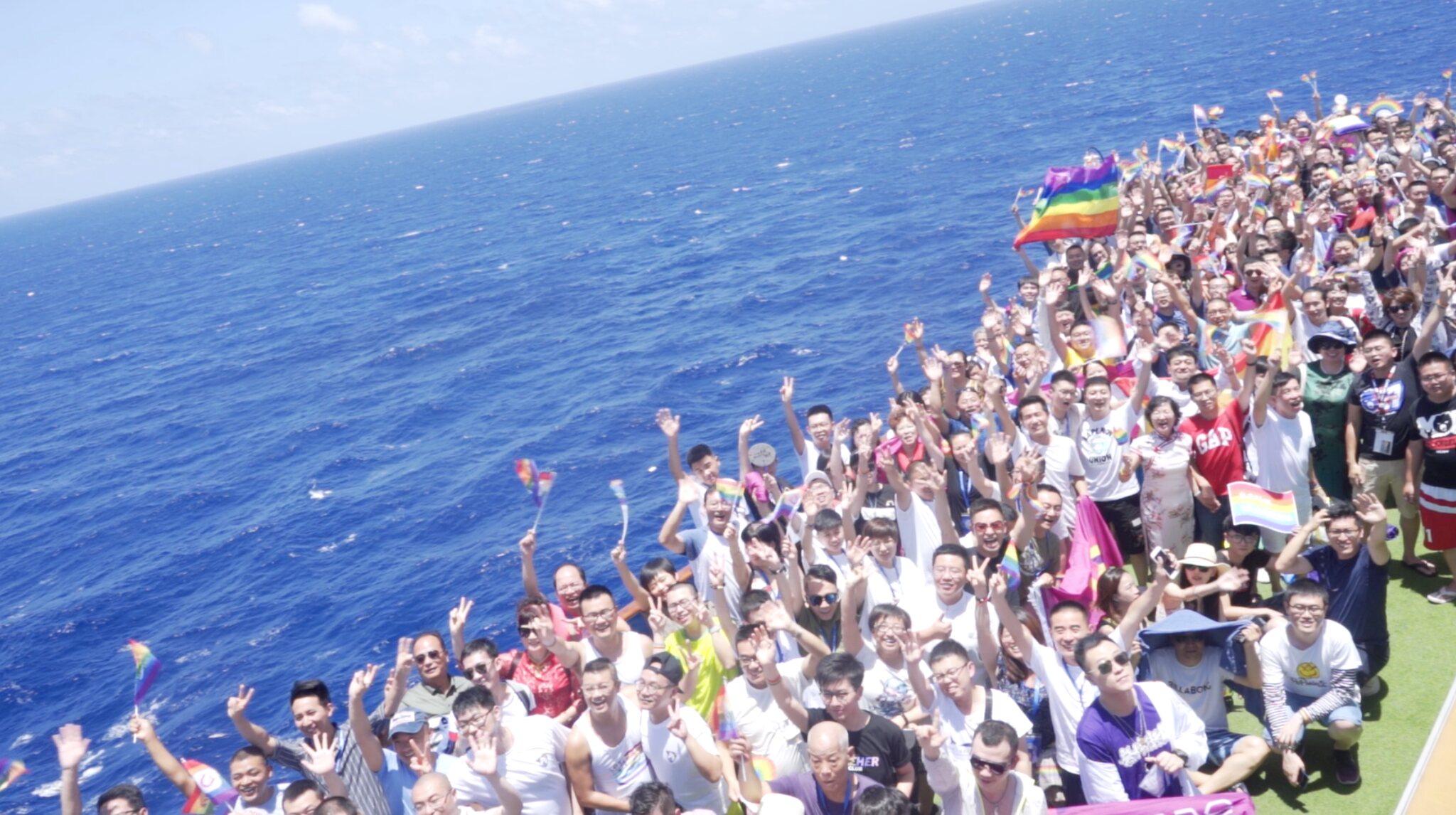 OutChina community members celebrating with Pride flags at sea